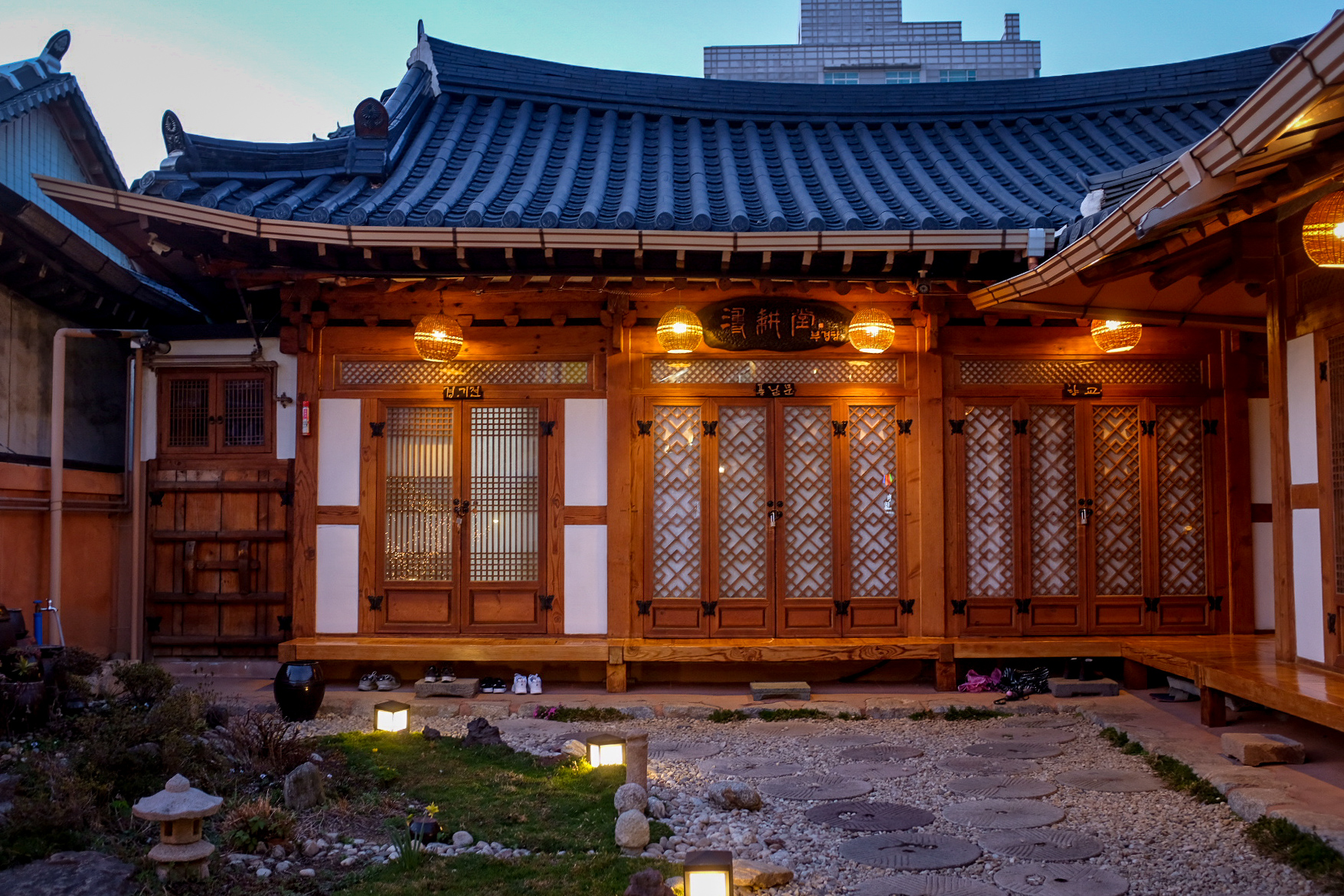 Traditional Korean wooden house, with paper-pasted doors and blue roof tiles.